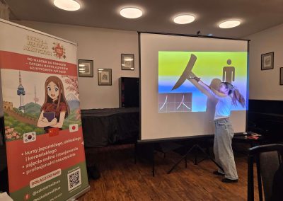 Lektorka uczy kaligrafii japońskiej uczestników warsztatów w Katowicach