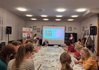 Uczestnicy warsztatów kaligrafii w DK Koszutka w Katowicach piszą znaki pędzlami